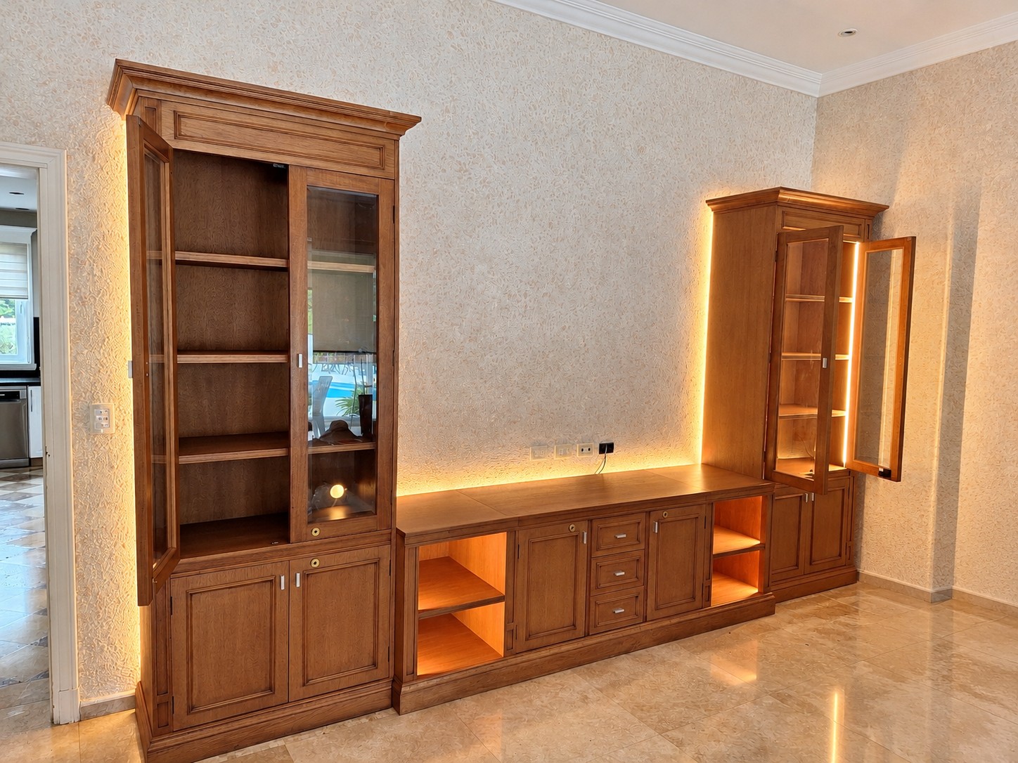 Mueble de TV y dos exhibidores de madera con iluminación LED, instalados en un living